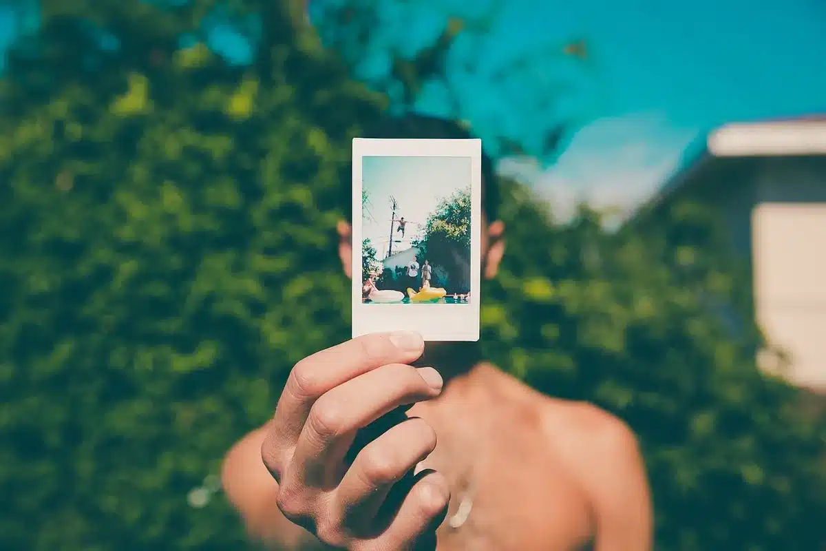 Hands arranging framed mementos and black-and-white photos on a sunlit table
