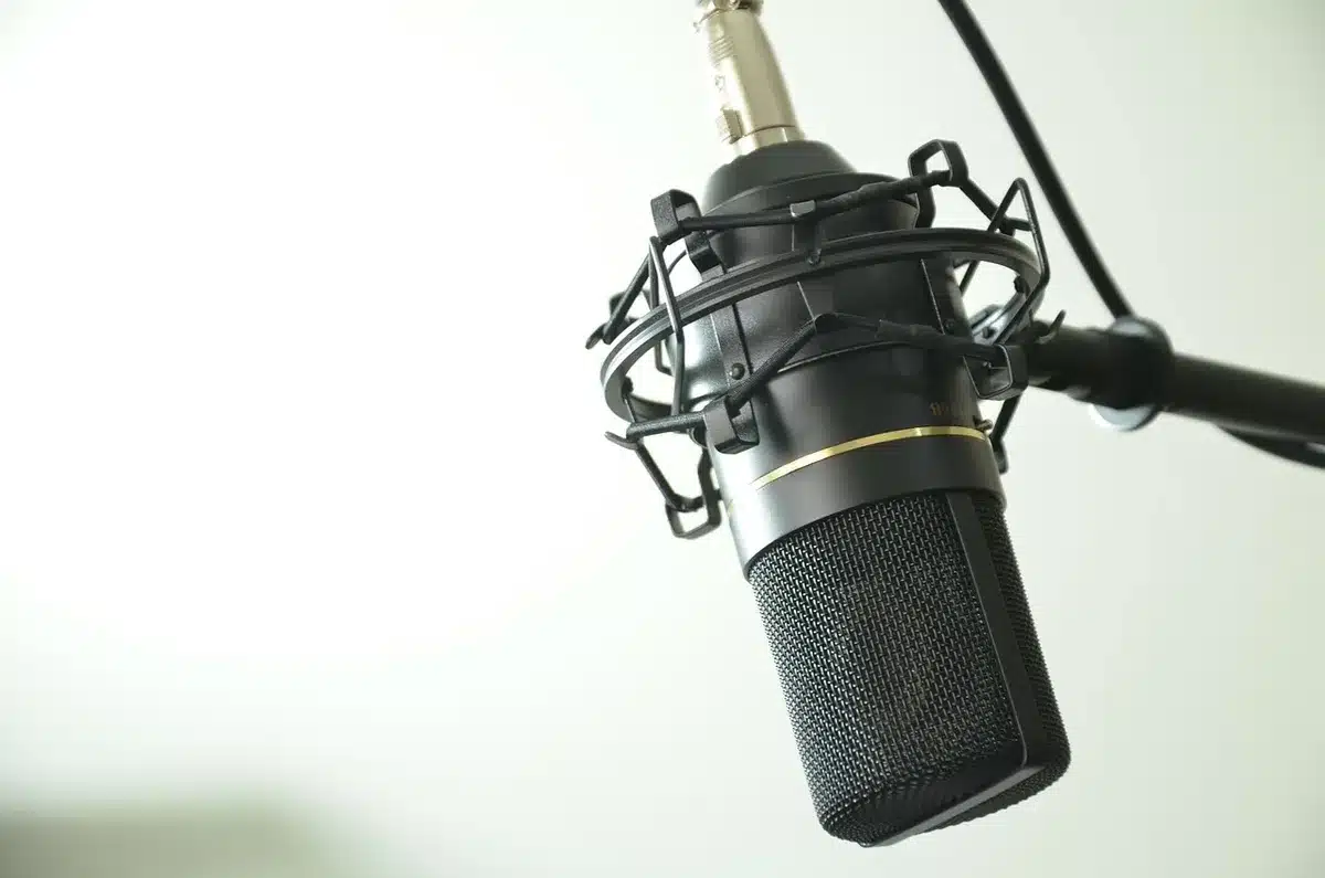Microphone de podcast sur fond flou de studio évoquant une discussion sportive