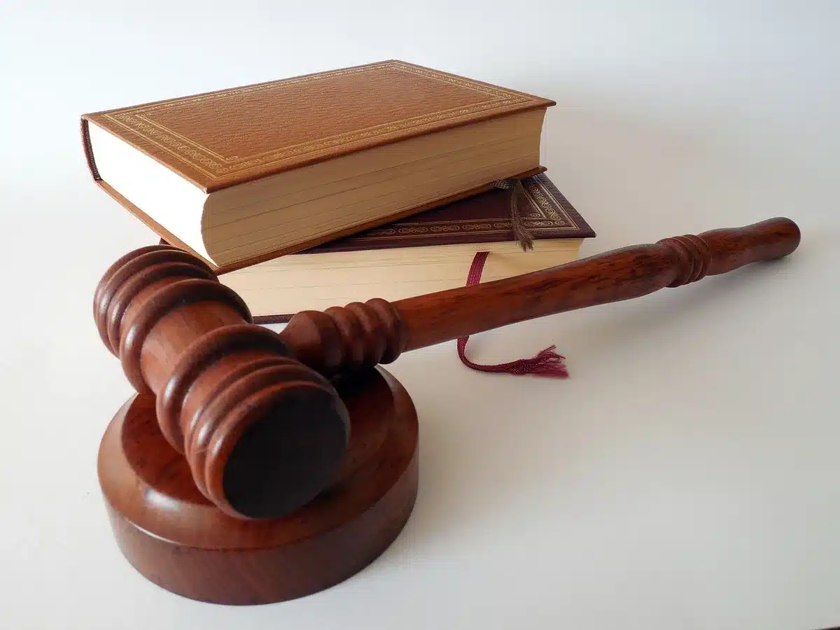 Anonymous hands passing an unbranded handgun over a table with blurred legal papers nearby